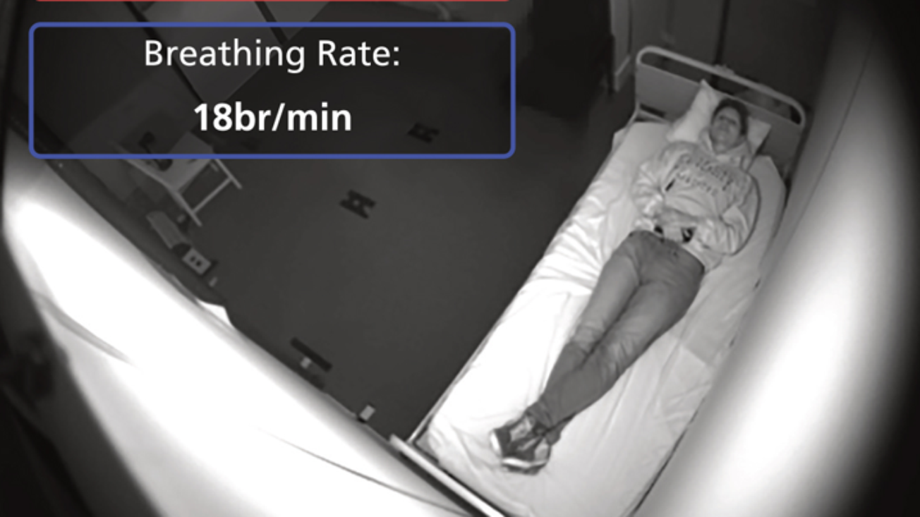 Image from a camera feed take by oxevision where a person is lying on their hospital bed