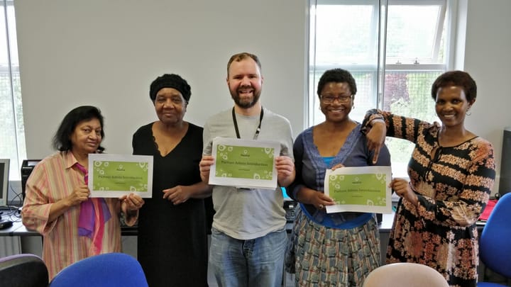 Five members of Manchester Age Friendly Neighbourhoods smiling at the camera after completing PlaceCal training.