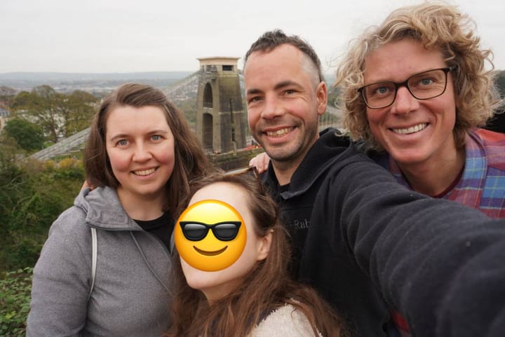 4 people gathering around to take a selfie infront of the Clifton suspension bridge in Bristol